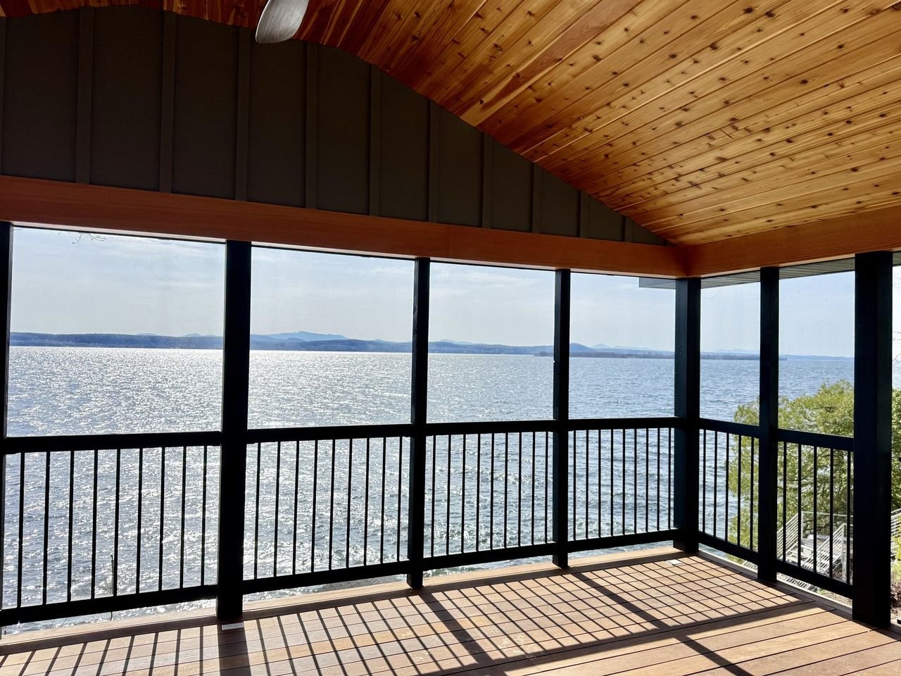 Screened porch with a cedar ceiling looking out over Lake Champlain