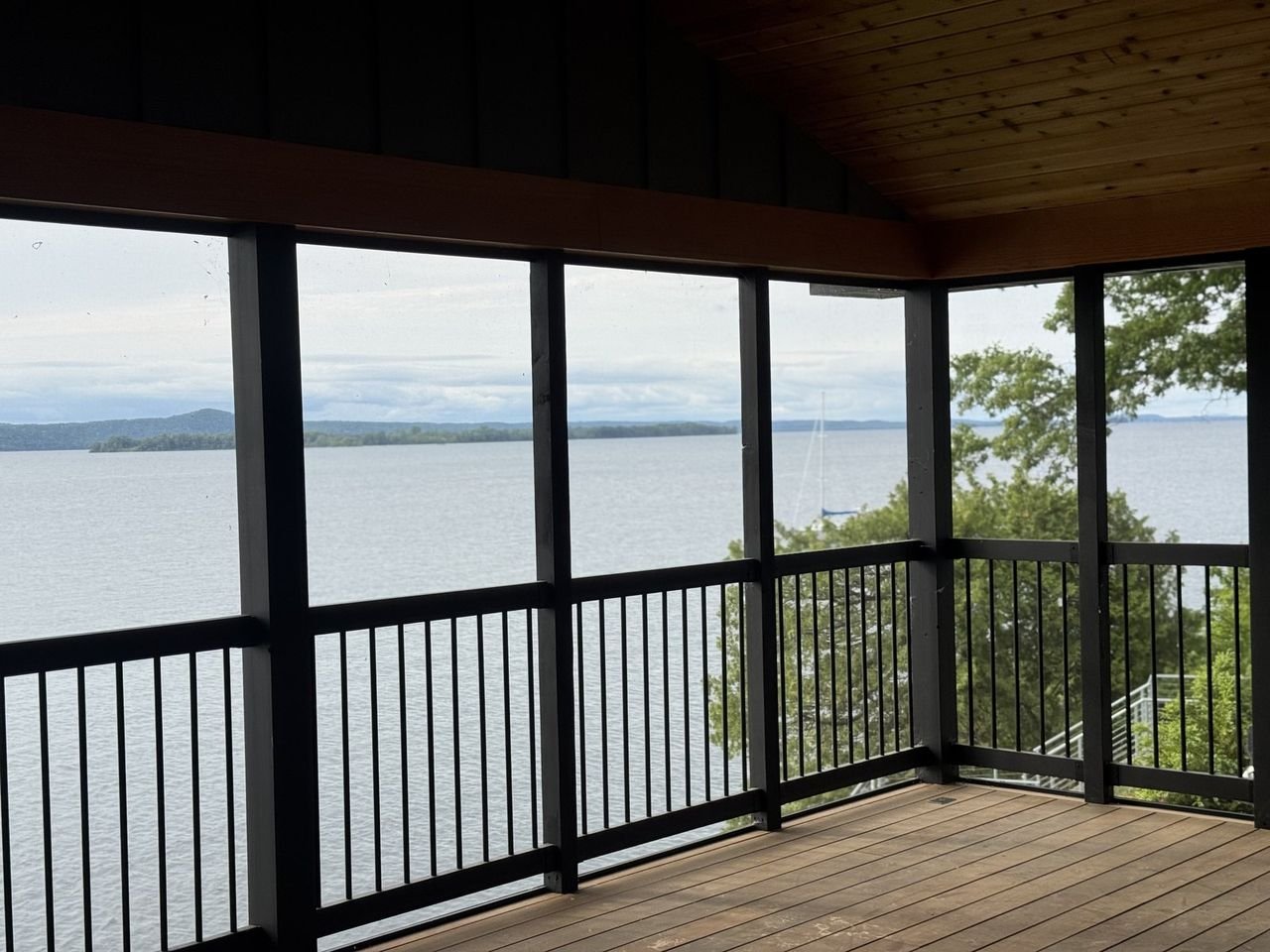 Screened porch with black-framed screens and an open lake view