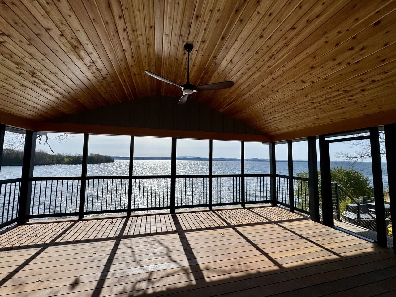 Screened porch interior with a cedar ceiling and ceiling fan