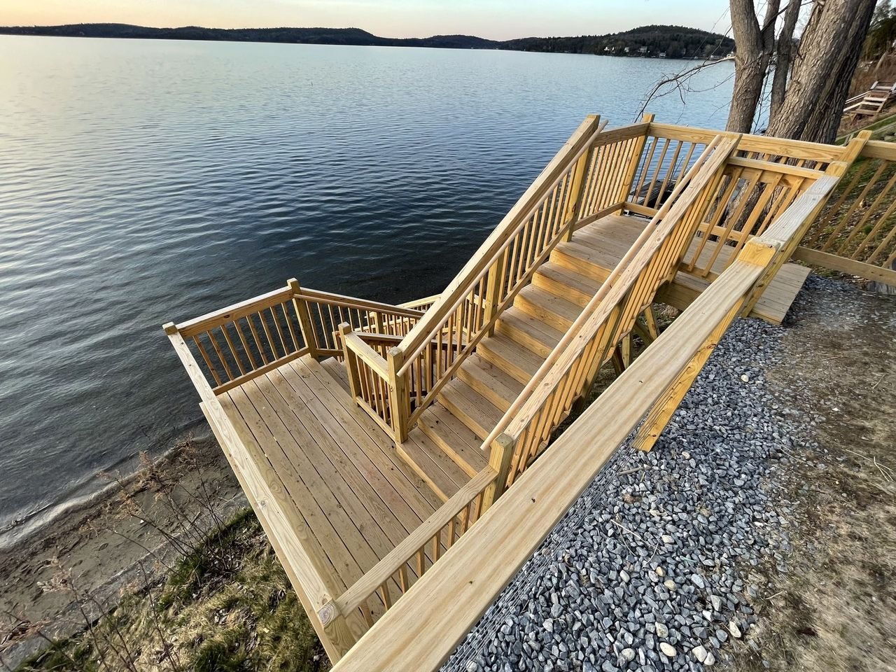 Cedar stair run and landing descending to a stone shoreline