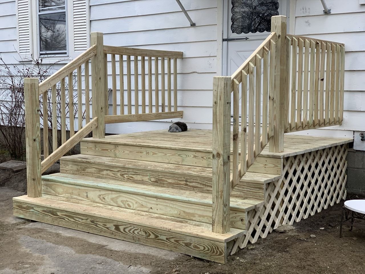 Pressure-treated entry stairs and landing against white siding